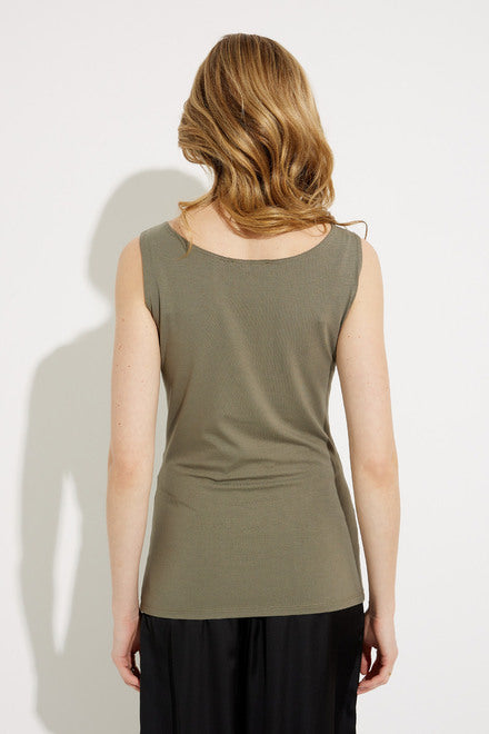 A woman stands against a plain background, wearing the Joseph Ribkoff Square Neck Camisole Style 232269 in Agave and black pants. She has blonde hair and smiles gently, with one hand resting on her hip. This ensemble exudes the timeless charm of a summer classic.