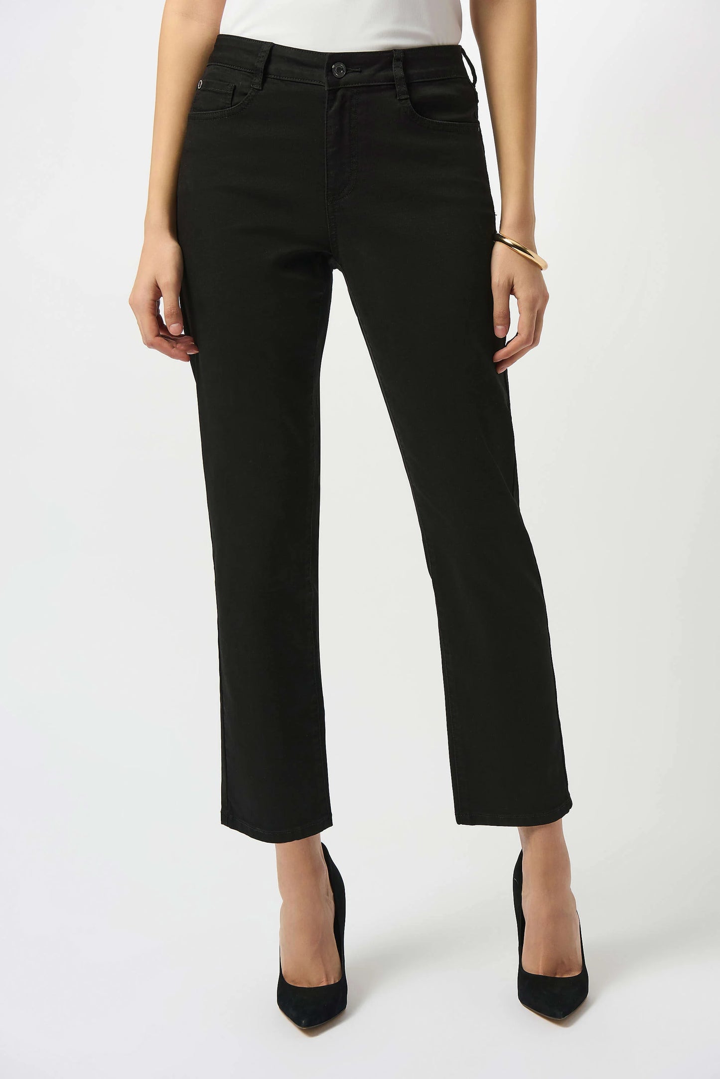 A person wearing Joseph Ribkoff’s Gia | Classic Slim Fit Stretch Jeans 251966B25, a white top, and black pointed-toe heels stands against a plain white background with only the lower half of their body visible.