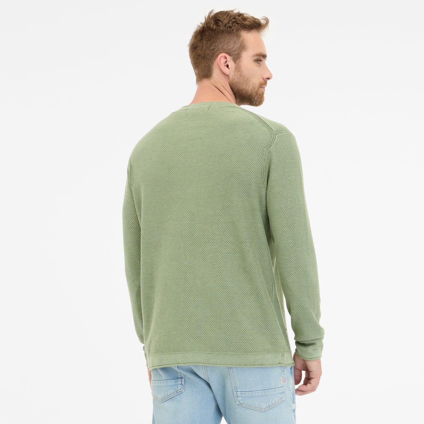 A man with short hair and a beard stands against a white background, wearing the RAGWEAR green cotton TORIEN 2512-35001-5033 long-sleeve shirt and light blue jeans—ideal for everyday wear.
