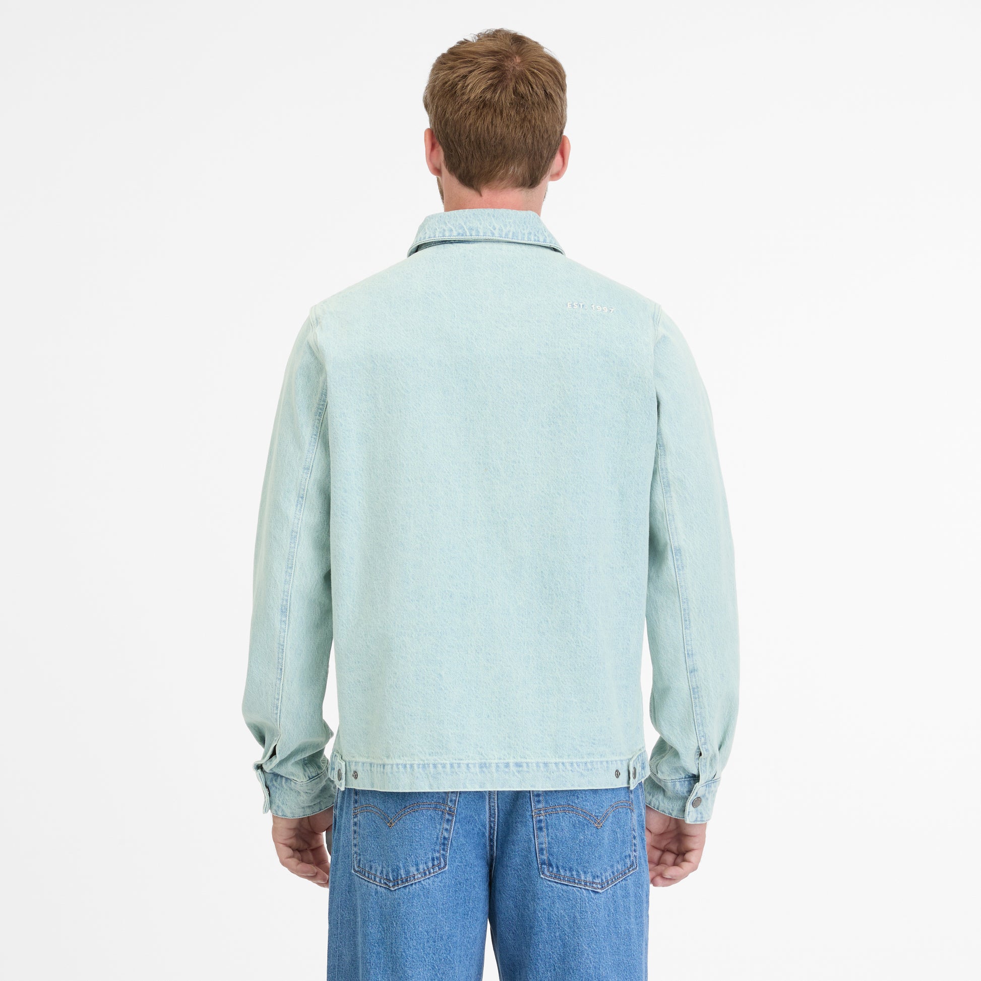 Facing away with short hair, a person wears a light blue CORDYREO DENIM 2512-60004-2042 by RAGWEAR with jeans against a plain white background, enhancing the casual look.