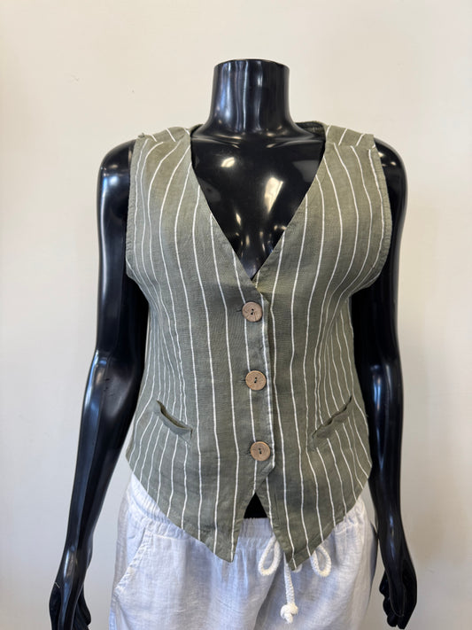 A black mannequin displays a Bella Amore Linen Vest 08003 in green pinstripe, made in Italy, featuring a V-neck and three wooden buttons. It has two pockets and is perfectly paired with white drawstring pants, all set against a plain white background.
