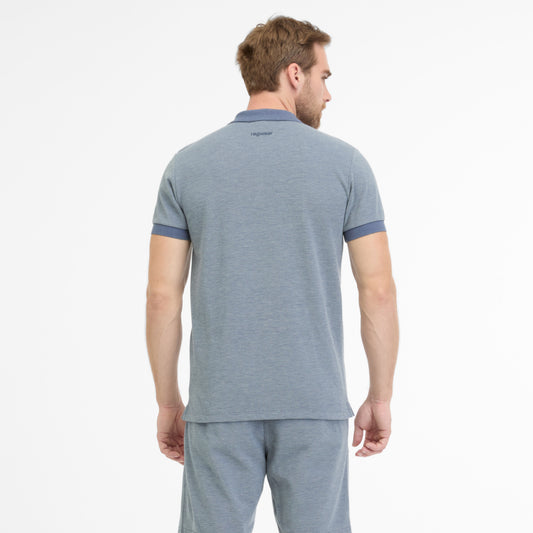 With his back to the camera, a man with light brown hair wears a RAGWEAR PORTILLO 2512-15007-2022 polo shirt and matching shorts in light gray. The plain white background accentuates his casual style.