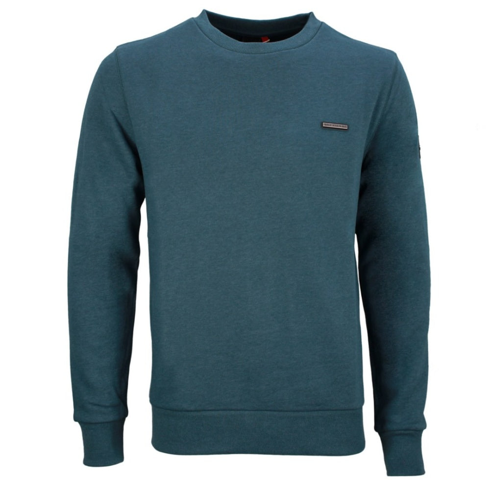 A smiling man with short brown hair is wearing a teal Ragwear Sweatshirt Pullover - INDDIE from RAGWEAR and black pants. He is standing against a plain white background, slightly turned to the side with his hands relaxed by his sides, showcasing a casual yet sporty look.