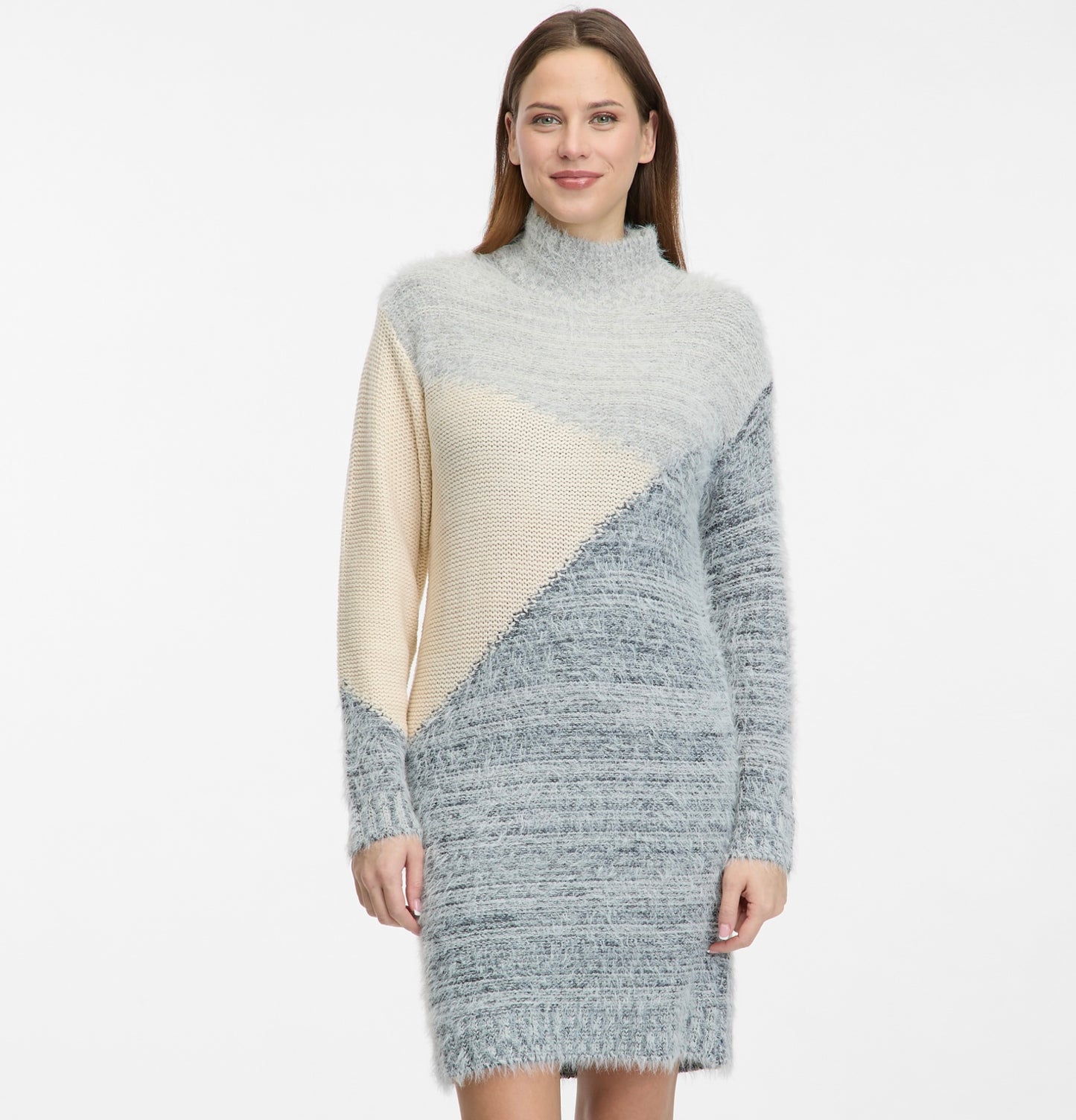 A woman smiles in the RAGWEAR YEROME Dress, a long-sleeved, fuzzy knit with light gray, beige, and blue diagonal color blocks and a high neckline, set against a plain white background.