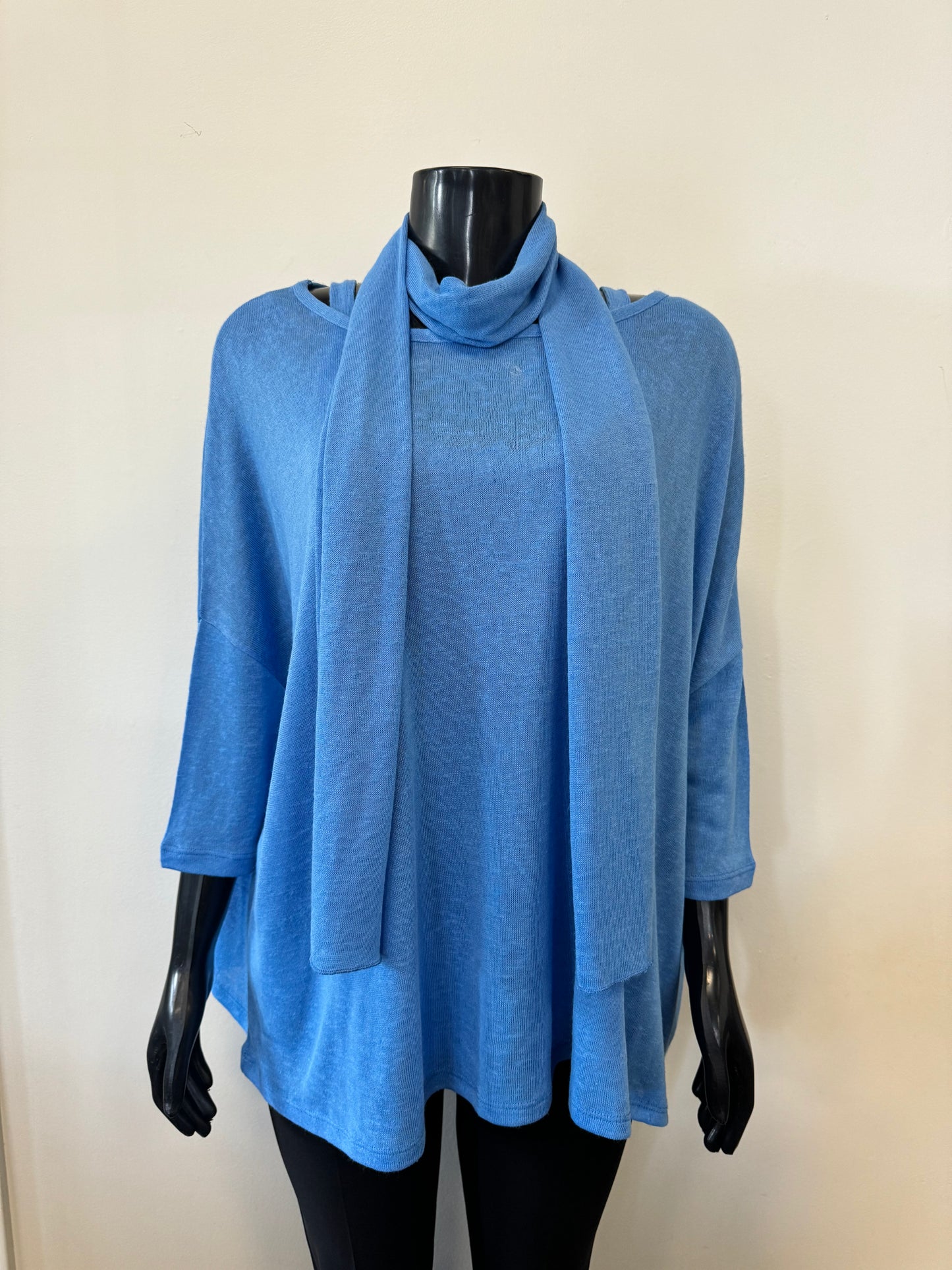 A black mannequin is showcasing a sleeveless, loose-fitting, blue tank top with a scooped neckline. The backdrop features a plain off-white wall. This stylish piece, part of the MARBLE Tank with Cover Top and Scarf set (Product Code: 6551 Marble), boasts thin shoulder straps and a simple, casual design.