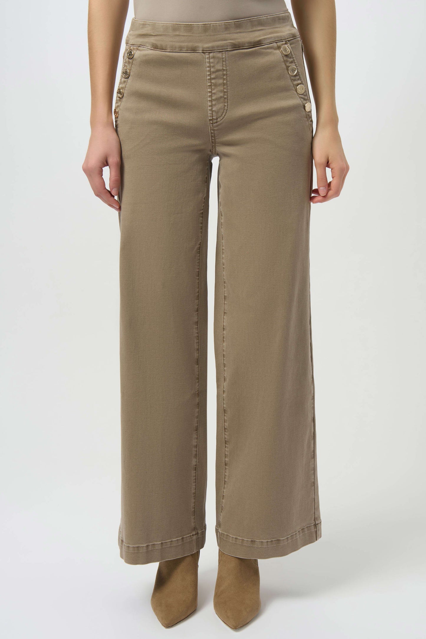 A person wearing Joseph Ribkoff Classic Wide Leg Pull-On Jeans 254919, featuring button-detailed pockets, styled with tan pointed-toe shoes. Image is cropped from the shoulders down.