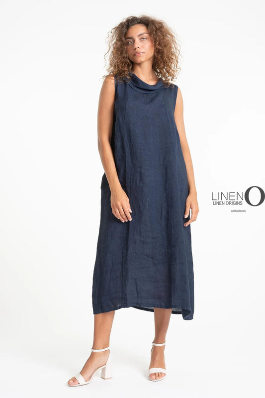 A woman with curly hair poses in LinenO's sleeveless French Linen Dress (TP1578-17 Blu/s), made from 100% linen. She pairs it with white strappy heels against a clean backdrop, while text reads "Linen Origins.
