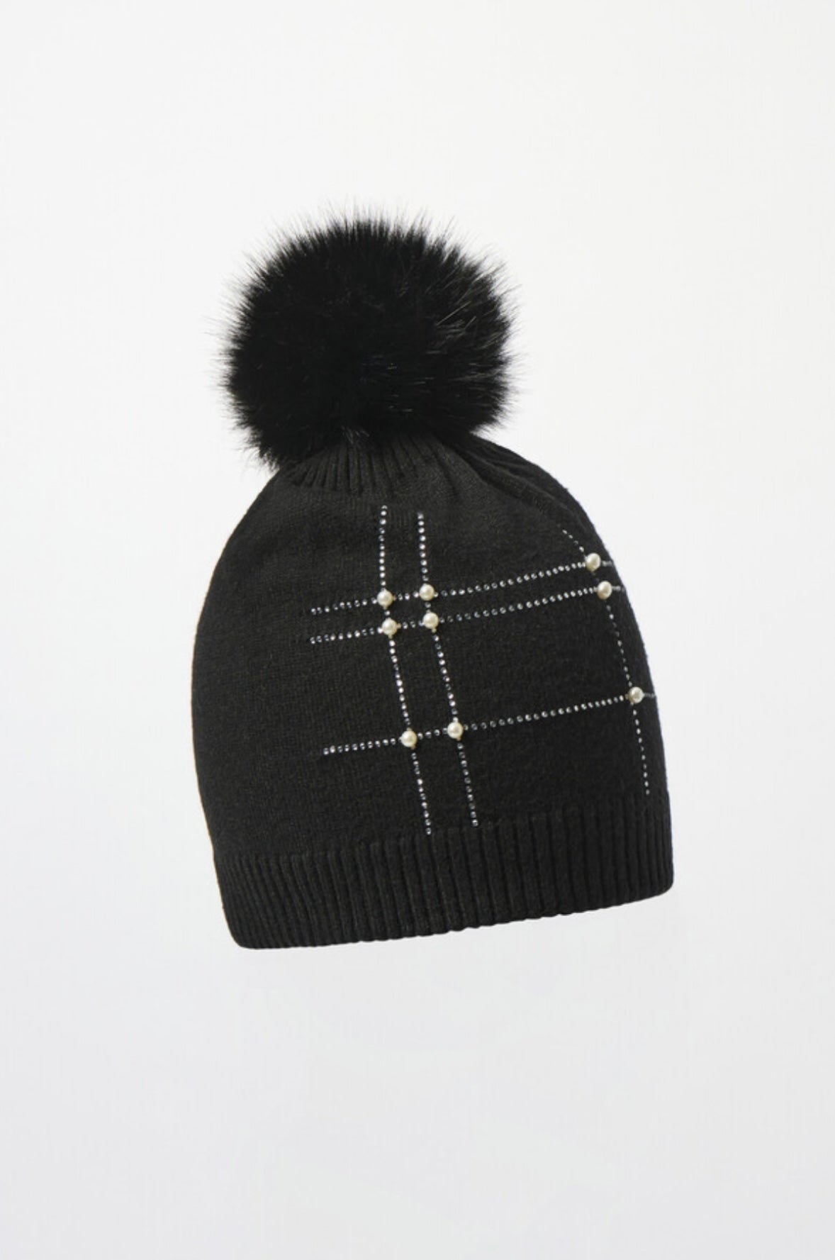 The Joseph Ribkoff Beaded Pom-pom Hat 253969 is a chic black knit beanie with a large faux fur pom-pom, silver studs, and pearls—an elegant winter accessory that stands out against a plain white background.