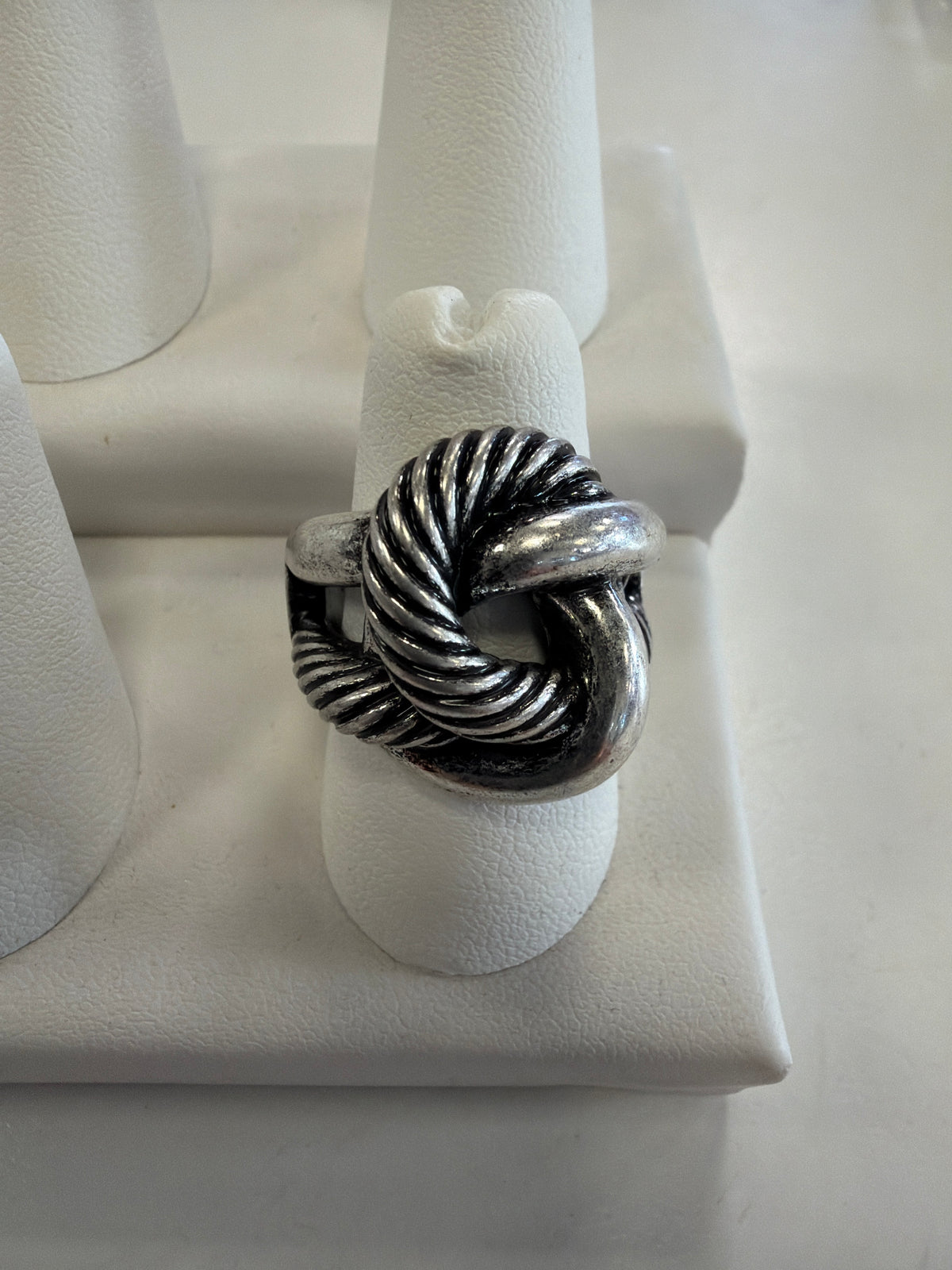 Jenna 98 Ring featuring an oxidized rope knot design, displayed on a white stand.