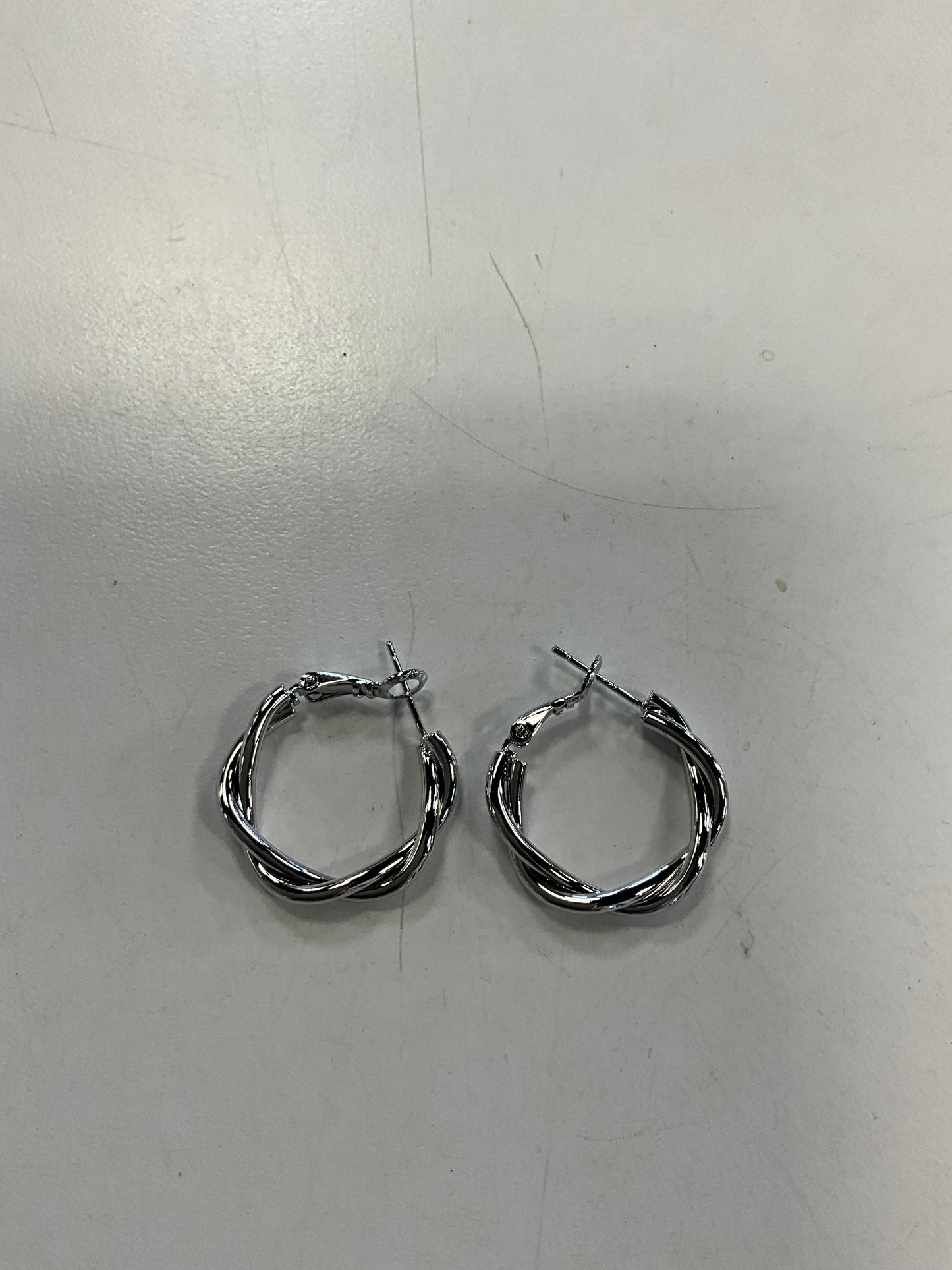 The Sky 1 Silver Hoop Earrings by Elise Accessories are small, twisted silver hoops with latch clasps—perfect as an elegant addition to your costume jewellery collection.