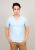 A person with short brown hair wears a light blue Johnny Collar Knit Shirt by HEDGE and beige pants, standing against a plain gray background with hands in pockets.