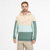 A person models the men's RAGWEAR BRESS HOODIE in beige, mint green, and dark teal with drawstrings and "ragwear" branding against a white background, paired with light beige pants.