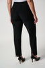 A person wearing the Classic Straight Pant in black by Joseph Ribkoff with slits at the ankles and black pointed heels, standing with their back to the camera. The person is also wearing a white top made of silky knit material. The background is plain white.