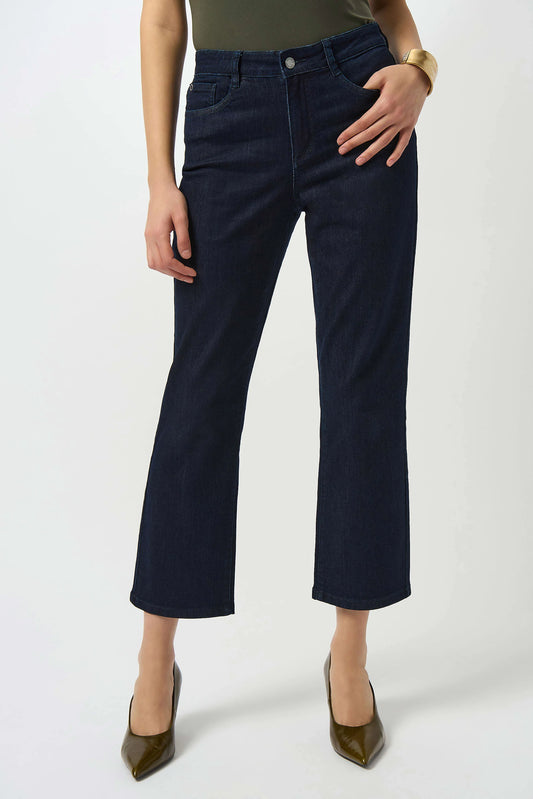 A person in dark blue Joseph Ribkoff Margot Classic Straight Leg Stretch Jeans 252926F25, a green top, gold bracelet, and olive green pointed-toe heels stands against a plain white background.