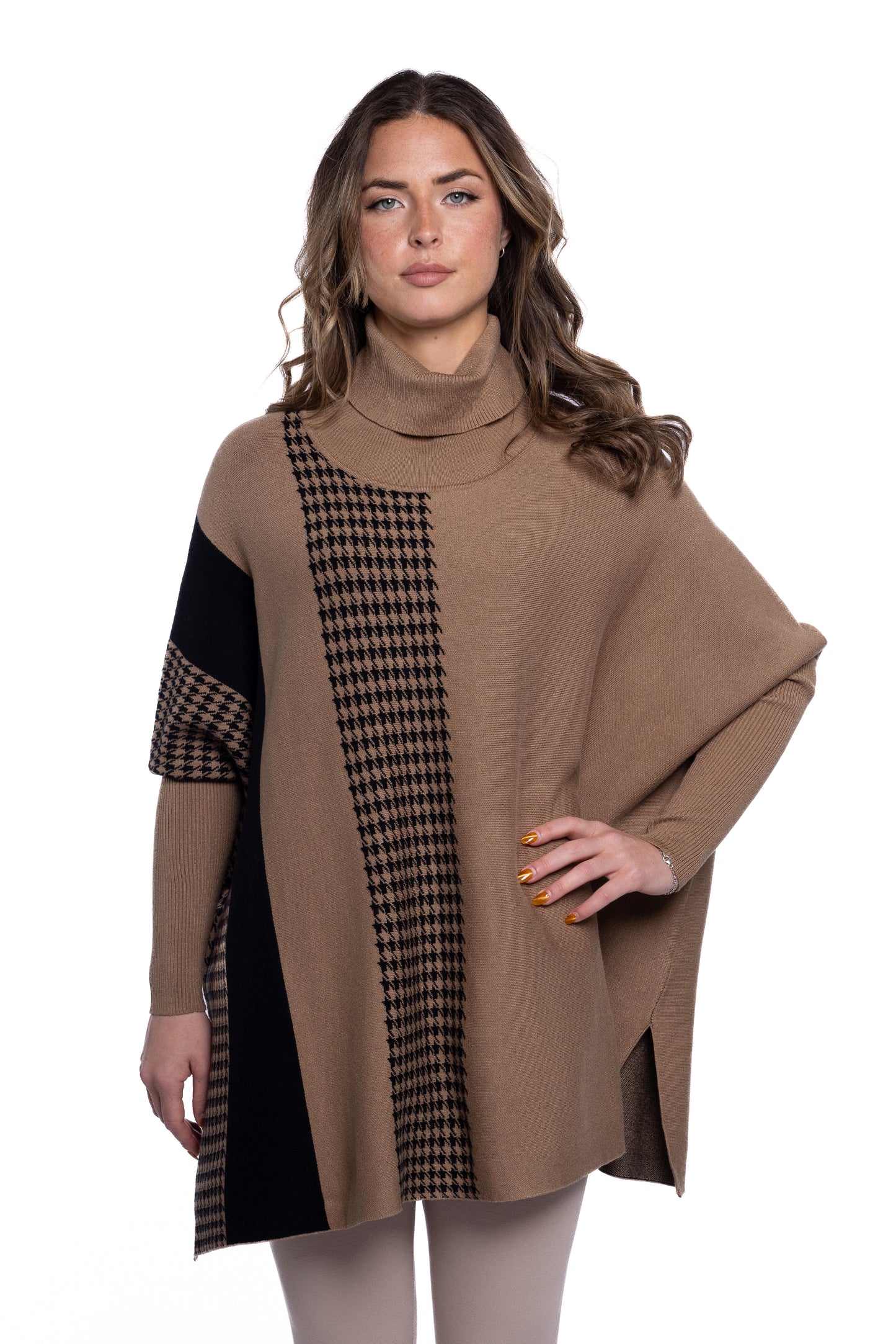 A woman with wavy, medium-length hair is wearing the Full Coat Turtle Neck Caramel by ETERNELLE. This Italian-made piece, crafted from a viscose mix, showcases a sophisticated blend of houndstooth and solid black patterns on the front. The brown turtleneck poncho perfectly complements her relaxed pose against the plain white background.