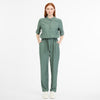 A person with long red hair stands against a white background wearing the PRESLYS JUMPER 2511-75004-5033 by RAGWEAR. They have their hands in their pockets, perfectly pairing it with matching drawstring pants and white sneakers for a soft, comfortable look.
