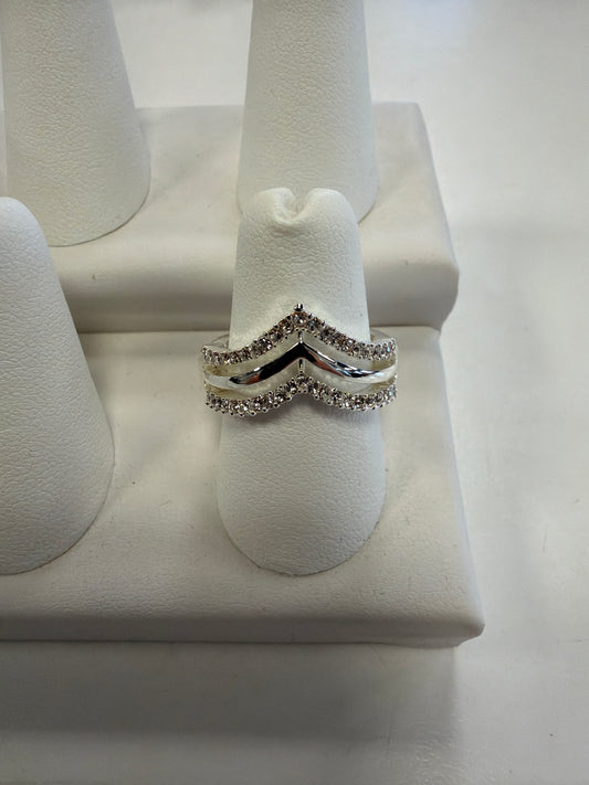 Jenna 81 Ring, a silver double chevron ring set with small clear CZ stones, displayed on a white ring stand.