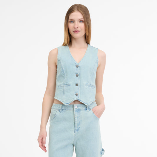 A person with light brown hair poses against a white background, wearing the chic SHAFRON DENIM VEST 2511-10057-2042 by RAGWEAR with buttons, and matching jeans, one hand in pocket.