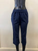 The Pant 6081 by SUNDAY is displayed on a black mannequin, showcasing navy blue cropped pants made from a linen-viscose blend with an elastic waistband, set against a plain pale wall.