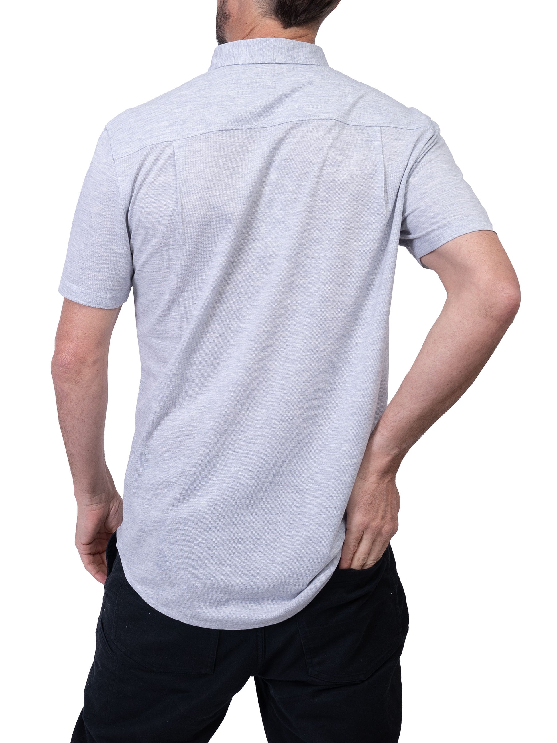 A man with a beard holds the top button of his Men’s Shirt Short Sleeve - LIGHT GREY from Silver Jeans Co. with his right hand. His left hand rests on his hip, complementing the relaxed vibe of his short-sleeved button-up shirt and dark pants.