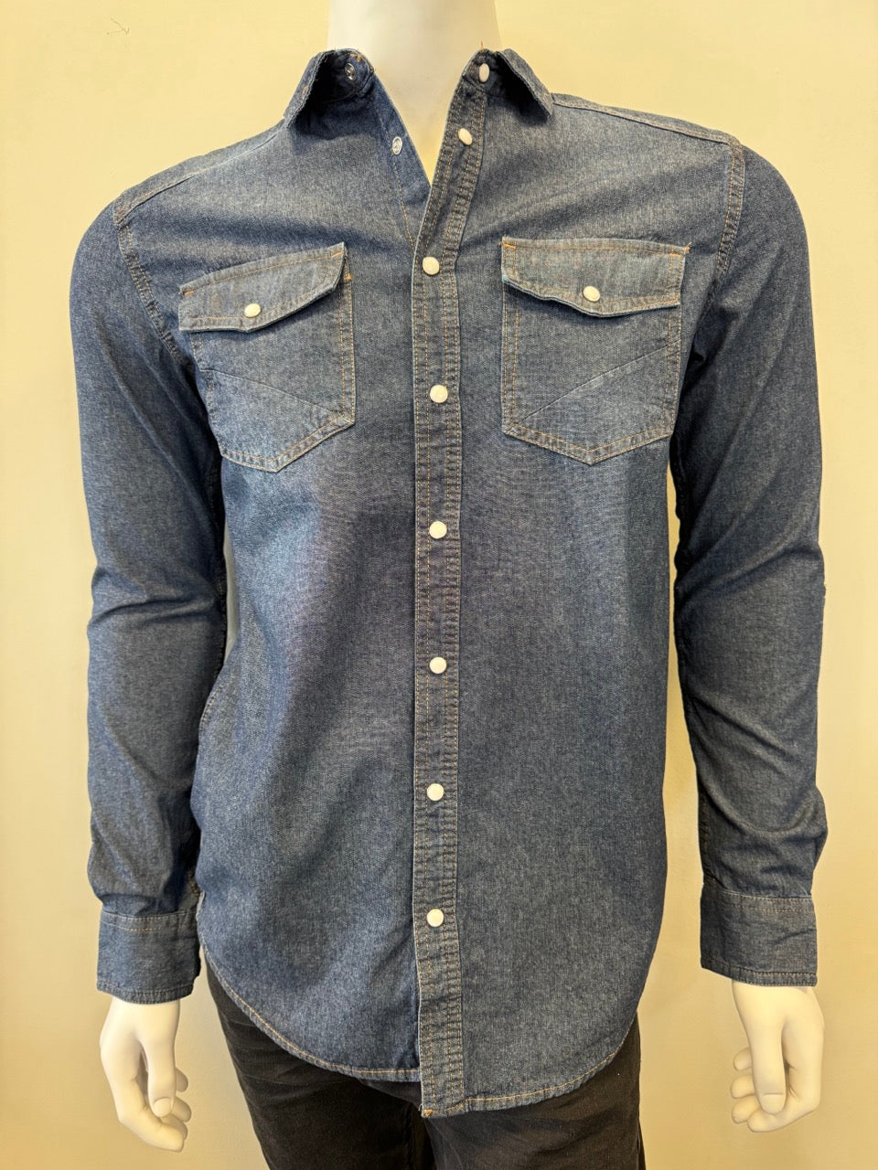 Mannequin dressed in a Silver Jeans Co. Denim Shirt Long Sleeve - MEDIUM WASH, featuring white buttons and two buttoned chest pockets. The 100% cotton shirt is displayed against a plain background, with the mannequin's lower half partially visible, wearing dark pants.