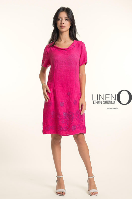 A woman in the LinenO French Linen Dress TP1745-43 Fuxia, featuring short sleeves and floral embroidery, poses confidently in white heels against a light background. "LINEN ORIGINS" appears beside her.