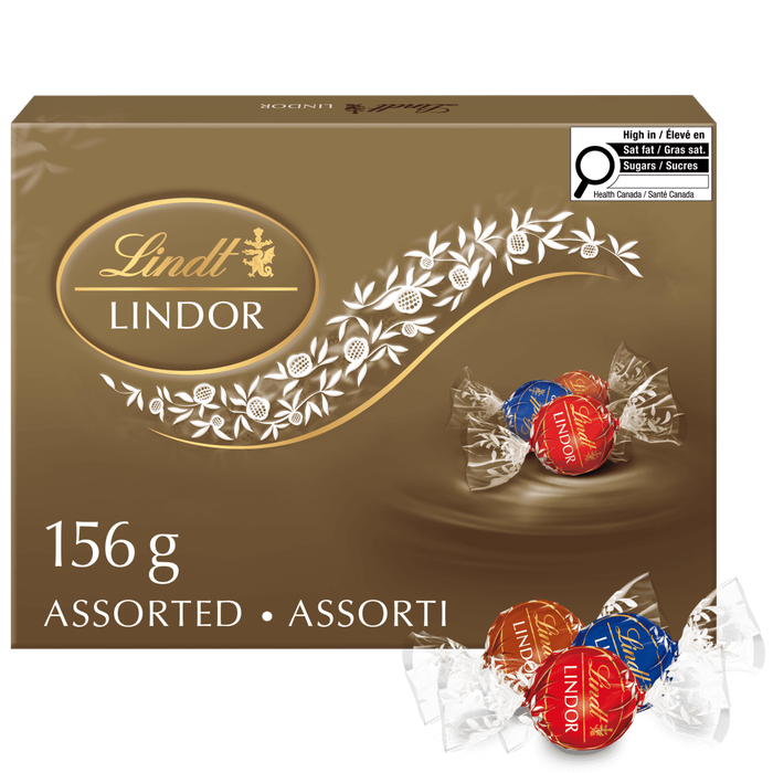 A Lindt Lindor LINDOR Assorted Milk and Dark Chocolate Truffles Box, 156g, is shown with milk and dark truffles on the packaging. Three individually wrapped truffles are placed in front of the box.