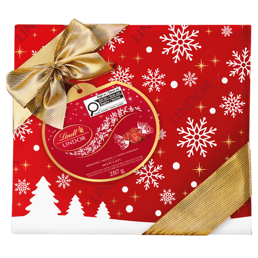 The Lindt Lindor LINDOR Milk Chocolate Truffles Gift Box, 287g, features festive red packaging with white snowflakes, gold stars, tree silhouettes, and a gold ribbon—perfect for holiday gifting with signature milk chocolate truffles.