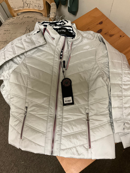 The JUNGE 91-Silver Puff Jacket 0126-2254-66, a light gray quilted jacket with red and white trim on the zippers and collar, is displayed flat on a wooden surface with a black tag attached to the front zipper.
