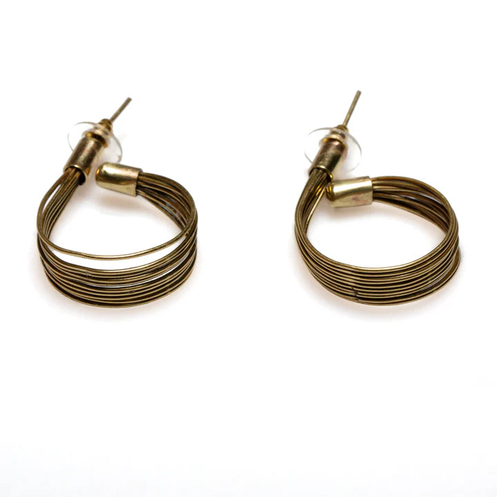 The Wire Loop Metal Earrings in Gold Colour by Suzie Blue showcase a distinctive twisted wire loop metal design and are secured with clear backings. Crafted from nickel-free plated brass, these earrings are displayed on a white background with their posts pointing upwards.