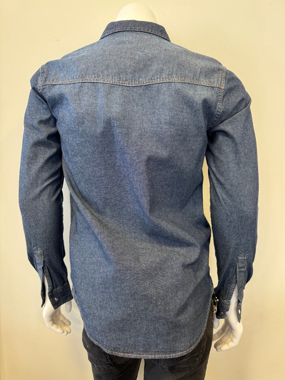 Mannequin dressed in a Silver Jeans Co. Denim Shirt Long Sleeve - MEDIUM WASH, featuring white buttons and two buttoned chest pockets. The 100% cotton shirt is displayed against a plain background, with the mannequin's lower half partially visible, wearing dark pants.