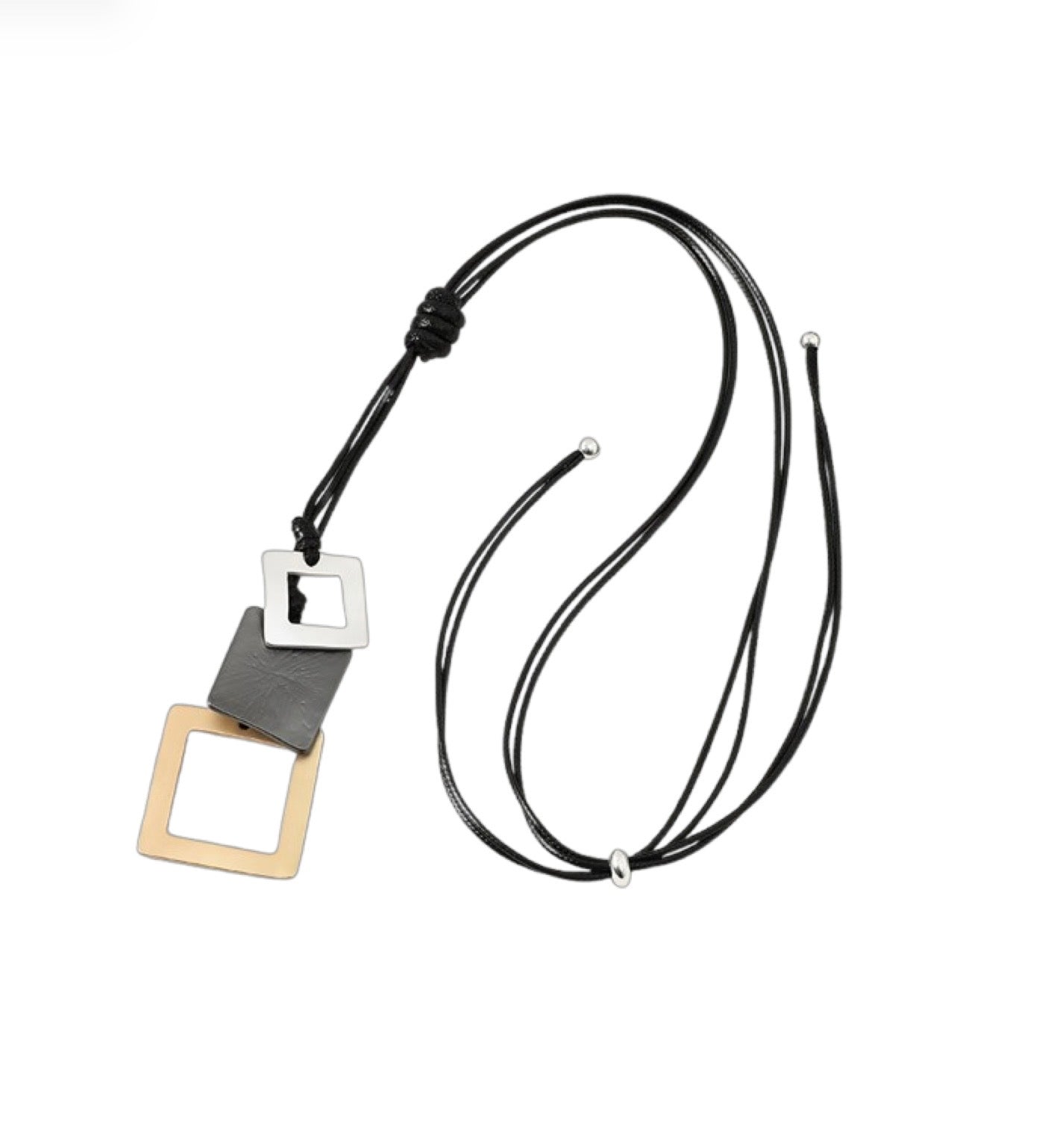 The Sofia 30 Necklace by Elise Accessories is a modern two-tone pendant necklace with a black cord and three overlapping geometric pendants—silver, black leather, and gold squares—for a bold statement look.