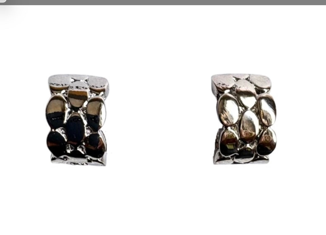 The Doris 15 Silver Clip-on Earrings by Elise Accessories feature a small square design with a textured, pebble-like surface—stylish modern costume jewellery perfect for any outfit. Displayed against a white background.