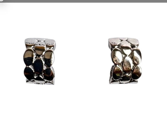 The Doris 15 Silver Clip-on Earrings by Elise Accessories feature a small square design with a textured, pebble-like surface—stylish modern costume jewellery perfect for any outfit. Displayed against a white background.