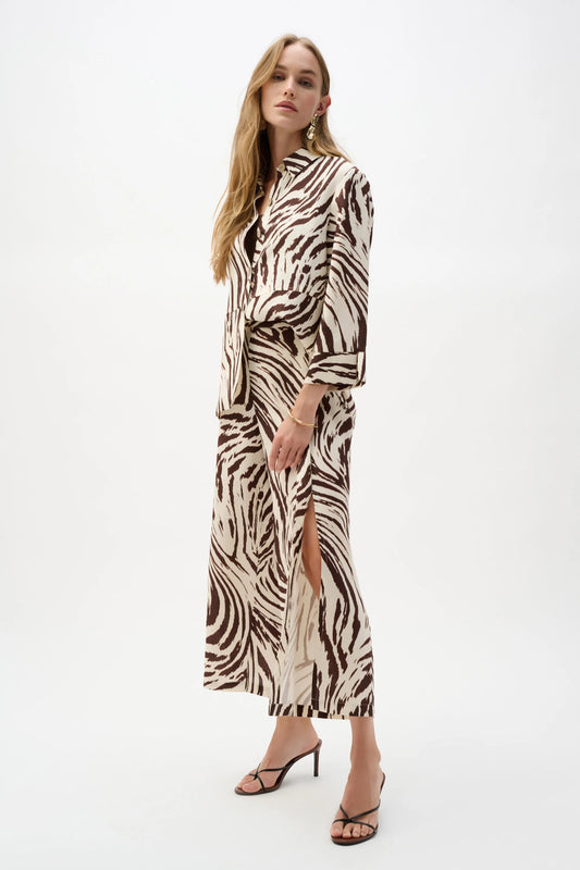 A woman stands against a white background wearing Joseph Ribkoff's Linen Blend Animal Print Culotte Pants With Pleats 262946, featuring an animal print and pull-on waistband, paired with a zebra-print jacket and black heeled sandals.