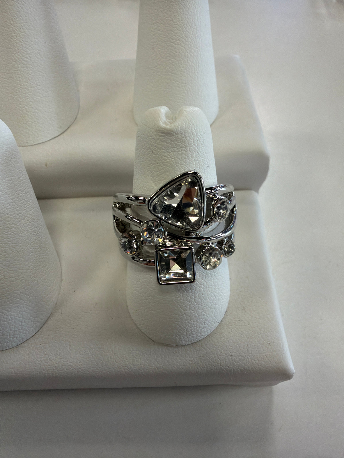 Jenna 90 Ring by Elise accessories featuring a silver-toned, multi-row CZ stretch band with a triangular stone, a square stone, and several small round accent stones.