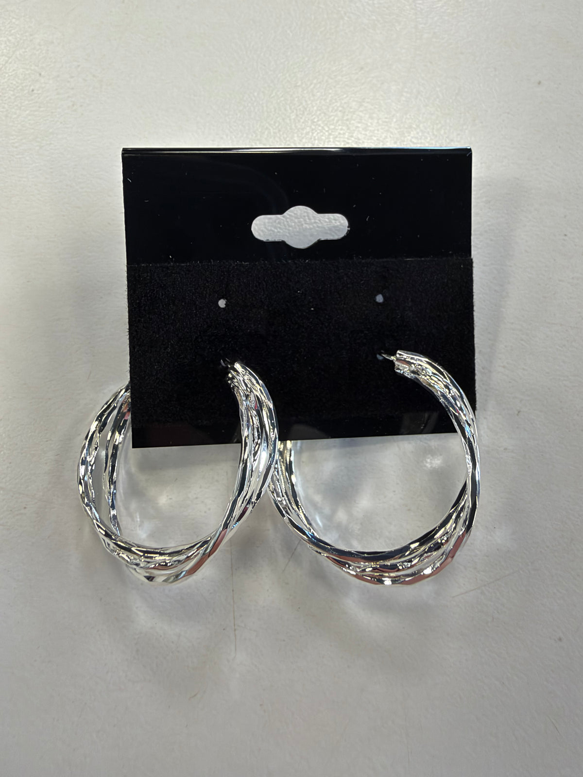 Sky 6 Earrings feature three-strand twisted silver hoops with a multi-layered design on a black display card.