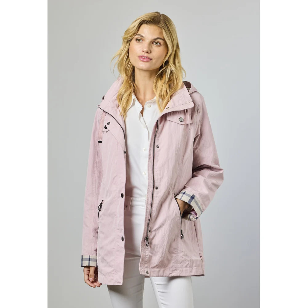 A woman with blonde hair wears the JUNGE Nellie Jacket - Rose 0126-2259–75 over a white shirt and pants, standing against a light gray background. She looks to the side with a soft smile.