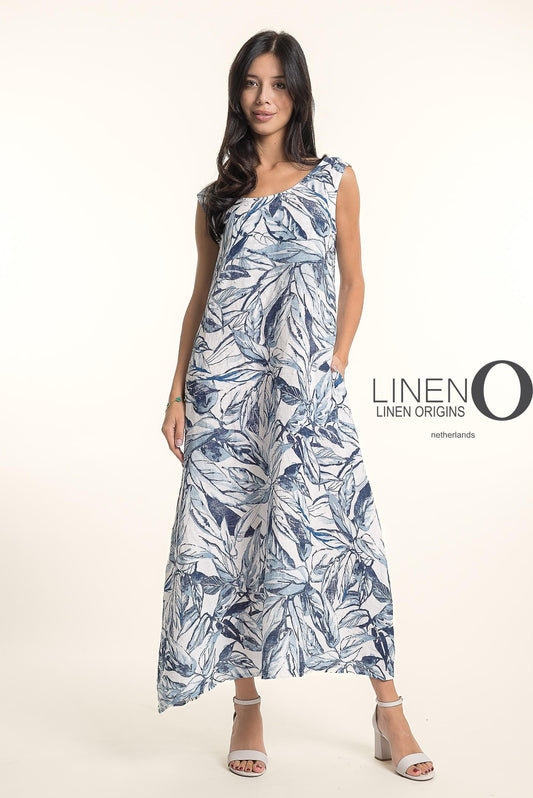 A woman with long dark hair wears white heeled sandals and the sleeveless, ankle-length French Linen Dress TP1720P-11 Bianca, featuring a blue and white leaf pattern by LinenO. "LINEN O" appears beside her against a light background.