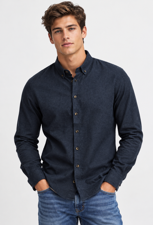 A man wearing a dark navy, long-sleeved cotton BHBURLEY Shirt -BLEND button-up and blue jeans, with his hands in his pockets.