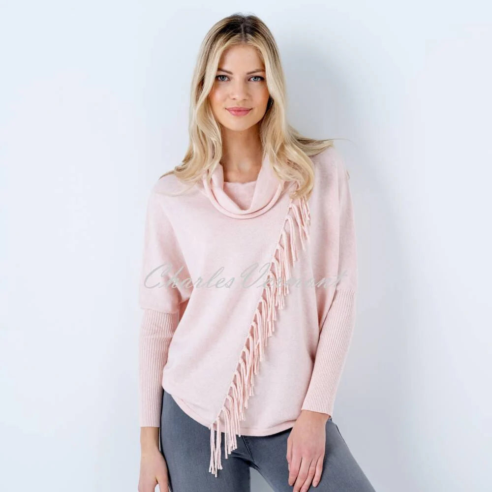 The Marble Long Sleeve Knit 6373 by MARBLE is a stylish, light pink, 100% cotton sweater that features a cowl neck and a diagonal fringe detail running from the left shoulder to the right waist. With ribbed sleeves from the elbow down, it offers a loose, relaxed fit.