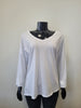 A black mannequin showcases the ETERNELLE V-Neck Long Sleeve Shirt -eternelle, a loose-fitting white cotton top, against a plain light gray background.