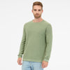 A man with short hair, wearing a TORIEN 2512-35001-5033 RAGWEAR cotton sweatshirt in light green and light blue jeans, stands against a plain white backdrop with a neutral expression facing the camera.