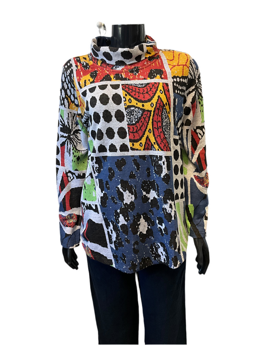 The mannequin is dressed in the Guillaume Mock Neck Top, Style: 22951 by ORIENTIQUE, featuring long sleeves and a vibrant patchwork pattern. This top boasts an elegant high collar and showcases a mix of geometric and abstract designs in black, white, red, yellow, green, and blue. Made from 100% organic cotton, it’s an ideal piece for bringing some color to your winter wardrobe. The mannequin's arms are straight and it’s paired with dark pants.