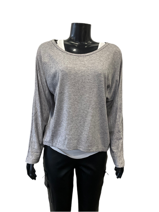 A black mannequin is dressed in a Top with Tank Top Grey by ETERNELLE, featuring a light grey, long-sleeve, loose-fitting top layered over a white tank top. The mannequin is also wearing black pants, and the background is plain white. This stylish grey top is crafted in Italy for that timeless elegance.