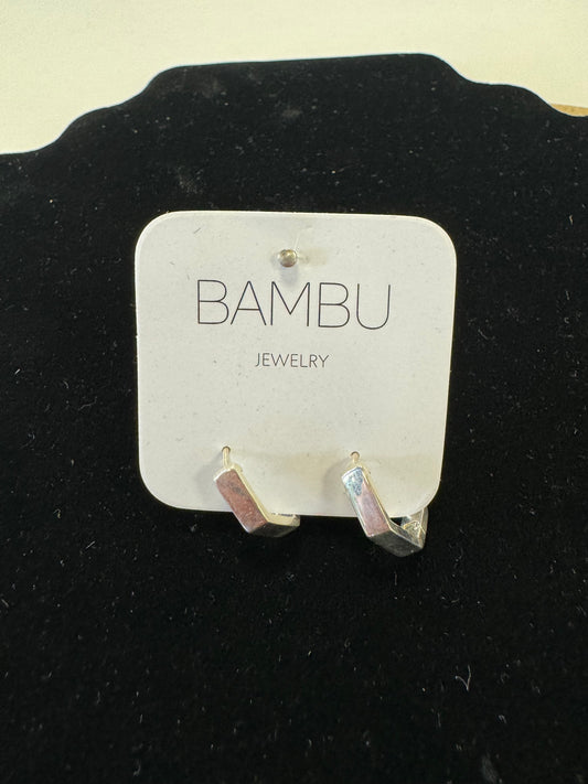 A pair of Silver Hexagon Earrings by BAMBU Jewelry are showcased on a white card with the "BAMBU Jewellery" brand name printed on it. The card is placed against a black fabric backdrop, enhancing the sophistication of this costume jewelry piece.