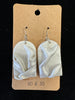 A pair of light gray, handmade Ro&Jo Earrings 433 with a wavy, textured design hangs on hooks attached to a brown cardboard backing. The backing has a small hole at the top for display purposes and the text "RO&JO" printed at the bottom.