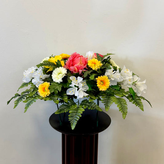 The 2 - Tombstone Saddle 60 cm Length by Posies Flowers & Fashion Inc. features yellow, white, and pink blooms with green ferns—perfect as a memorial saddle arrangement for honoring loved ones at the cemetery.