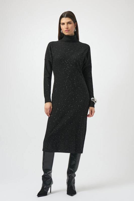 A woman stands against a plain background in the Joseph Ribkoff Sequined Sweater Knit Turtleneck Sheath Dress 254932, styled with black knee-high heeled boots, silver hoop earrings, and sleek straight dark hair.