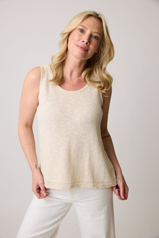 A person with blonde hair is wearing the eco-friendly Parkhurst Eco Tank Natural 70182 and white pants, standing against a plain background. They smile slightly, exuding a relaxed casual posture.